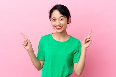Pembe arka planda izole edilmiş genç Vietnamlı kadın harika bir fikre işaret ediyor.