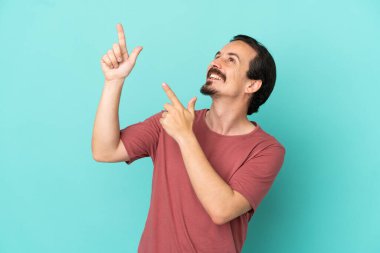 Mavi arka planda izole edilmiş genç beyaz adam işaret parmağıyla işaret etmek harika bir fikir.