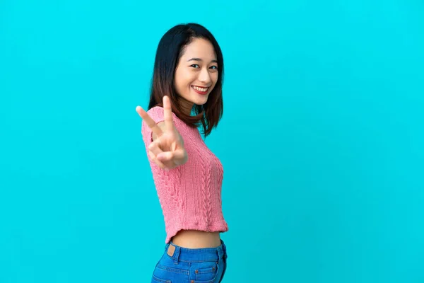 Young Vietnamese Woman Isolated Blue Background Smiling Showing Victory Sign — Stock Photo, Image