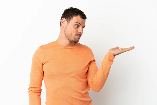 Hombre Brasileño Sobre Fondo Blanco Aislado Sosteniendo Copyspace Con Dudas —  Fotos de Stock