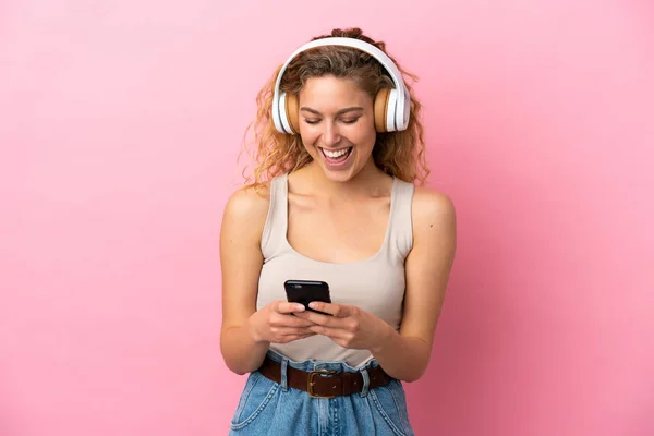 Jeune Femme Blonde Isolée Sur Fond Rose Écoutant Musique Regardant — Photo