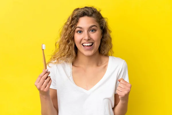 Młoda Biała Kobieta Trzyma Szczotkujące Zęby Odizolowane Żółtym Tle Świętując — Zdjęcie stockowe