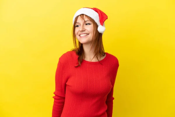 Κοκκινομάλλα Χριστουγεννιάτικο Καπέλο Απομονωμένο Κίτρινο Φόντο Κοιτάζοντας Στο Πλάι Και — Φωτογραφία Αρχείου