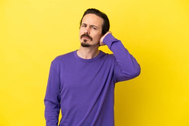 Sarı arka planda izole edilmiş genç beyaz adamın şüpheleri var.