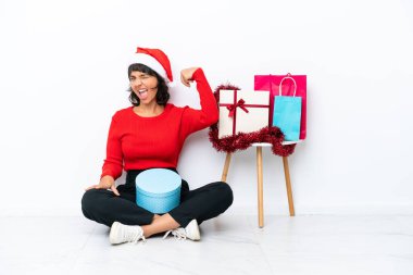 Genç bir kız Noel 'i kutluyor. Beyaz fırında yapayalnız oturuyor. Güçlü bir jest yapıyor.