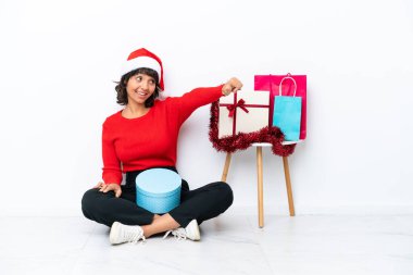 Genç bir kız Noel 'i kutluyor. Beyaz fırında yapayalnız bir şekilde yerde oturuyor.