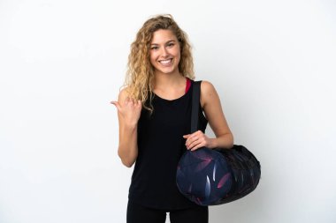 Spor çantalı genç bayan beyaz arka planda izole edilmiş bir ürün sunmak için kenarı işaret ediyor.