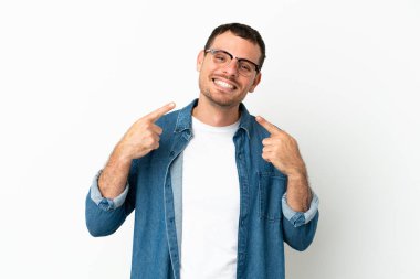 İzole edilmiş beyaz arka planda Brezilyalı bir adam baş parmak hareketi yapıyor.