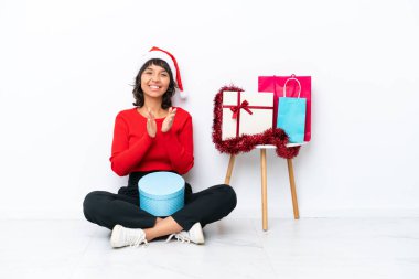 Noel 'i kutlayan genç bir kız beyaz bir fırın alanında izole bir şekilde oturmuş bir konferanstan sonra alkışlıyor.