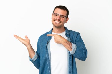 İzole edilmiş beyaz arkaplan üzerinde Brezilyalı bir adam bir ilan vermek için avucunda hayali bir metin tutuyor.