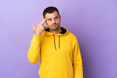 Brezilyalı bir adam mor arka planda intihar jesti yapmada sorun yaşıyor.