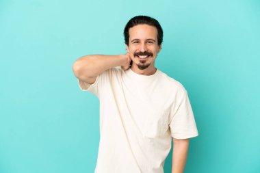 Kafkasyalı genç adam mavi arka planda tek başına gülüyor.