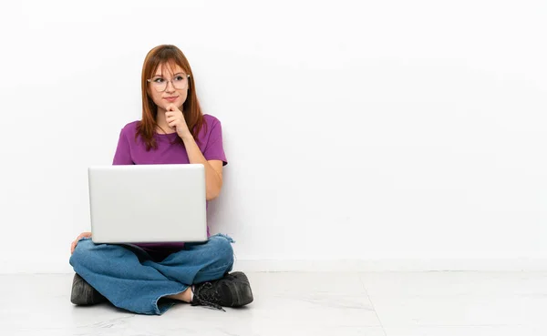 Rothaariges Mädchen Mit Laptop Auf Dem Boden Sitzend Und Aufblickend — Stockfoto