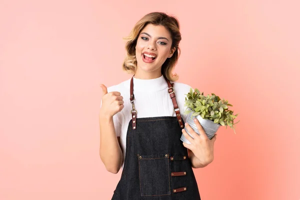 Menina Jardineiro Russo Segurando Uma Planta Isolada Fundo Rosa Dando — Fotografia de Stock