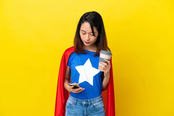 Super Bohater Wietnamka Odizolowana Żółtym Tle Trzymając Kawę Zabrania Telefon — Zdjęcie stockowe