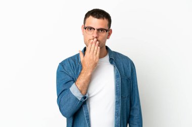 İzole edilmiş beyaz arka planı olan Brezilyalı bir adam ağızı eliyle kapatıyor.