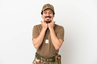 Beyaz arka planda izole edilmiş mutlu ve hoş bir ifadeyle gülümseyen bir asker.