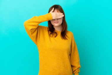 Kızıl saçlı kız mavi arka planda tek başına, gözleri elle kapatıyor. Bir şey görmek istemiyorum.