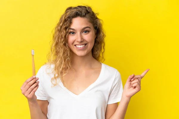 Jonge Blanke Vrouw Met Een Poetstanden Geïsoleerd Gele Achtergrond Wijzend — Stockfoto