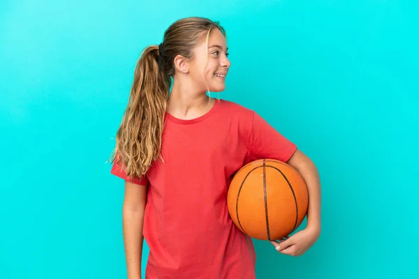 Pequeña Chica Caucásica Jugando Baloncesto Aislado Sobre Fondo Azul Mirando —  Fotos de Stock