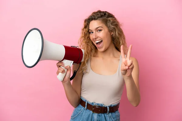 Jonge Blonde Vrouw Geïsoleerd Roze Achtergrond Met Een Megafoon Glimlachen — Stockfoto