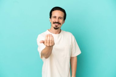 Kafkasyalı genç bir adam mavi arka planda izole edilmiş ve davet edilmişti. Gelmene sevindim.