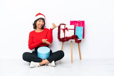 Genç bir kız Noel 'i kutluyor. Beyaz fırında yapayalnız oturuyor. Davet edildiği için ellerini yana açıyor.