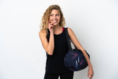 Spor çantalı genç bir kadın beyaz arka planda izole edilmiş bir şekilde yukarı bakarken bir fikir düşünüyor.