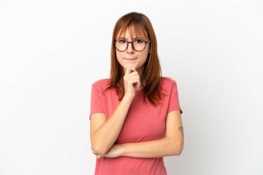 Kızıl saçlı kız beyaz arka planda izole edilmiş. Şüpheleri ve düşünceleri var.