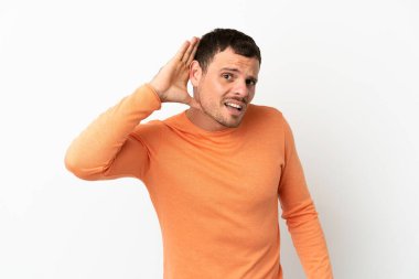 İzole edilmiş beyaz arka plan üzerinde Brezilyalı bir adam. Kulağına elini sürerek bir şey dinliyor.