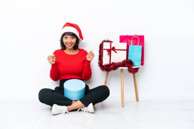 Genç bir kız Noel 'i kutluyor. Beyaz bir fırında tek başına oturmuş zaferi kutluyor.