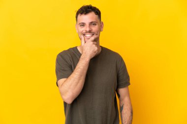 Beyaz tenli yakışıklı bir adam sarı arka planda izole edilmiş.