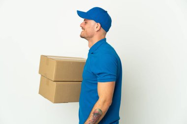 Teslimat beyaz arka planda izole edilmiş beyaz adam. Yan pozisyonda gülüyor.