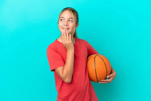 Malá Kavkazská Dívka Hraje Basketbal Izolované Modrém Pozadí Vzhlíží Usmívá — Stock fotografie