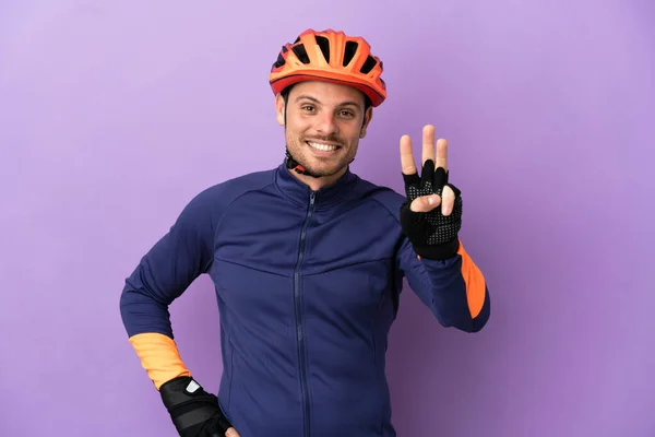Joven Ciclista Brasileño Aislado Sobre Fondo Morado Feliz Contando Tres — Foto de Stock