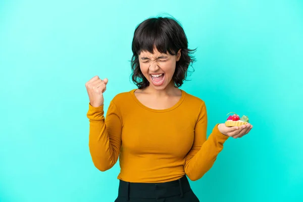 Fiatal Vegyes Faj Kezében Egy Tartlet Elszigetelt Kék Háttér Ünneplő — Stock Fotó