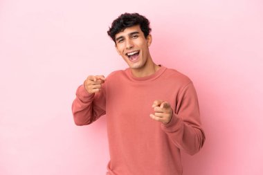 Pembe arka planda izole edilmiş genç Arjantinli adam öne bakıyor ve gülümsüyor.