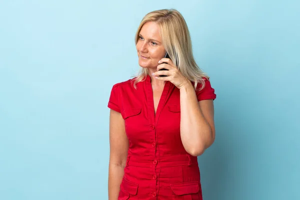 Женщина Средних Лет Изолированная Синем Фоне Поддерживает Разговор Кем Мобильному — стоковое фото