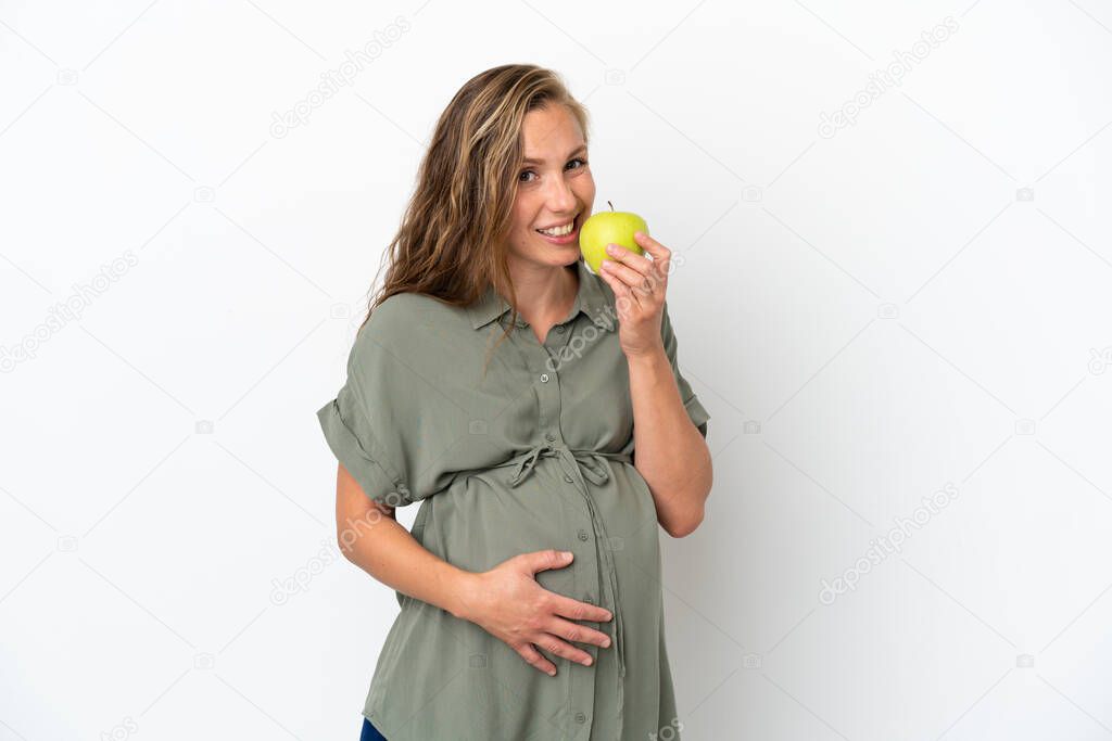 Young caucasian woman isolated on white background pregnant and holding an apple