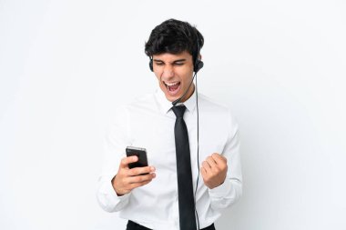 Beyaz arka planda izole edilmiş bir kulaklıkla çalışan pazarlamacı şaşırdı ve bir mesaj gönderiyor.