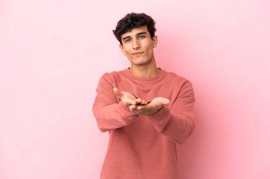 Pembe arka planda izole edilmiş genç Arjantinli bir adam.