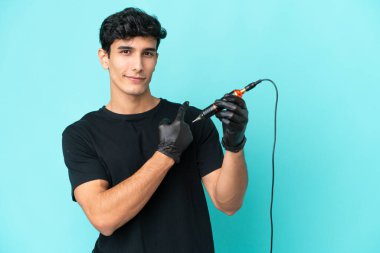 Dövme sanatçısı Arjantinli adam mavi arka planda izole edilmiş.