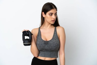 Beyaz arka planda izole edilmiş genç beyaz kadın halter olarak ağırlık kaldırıyor.