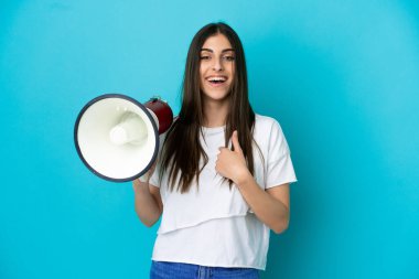 Mavi arka planda izole edilmiş beyaz bir kadın elinde bir megafonla ve şaşırmış bir yüz ifadesiyle