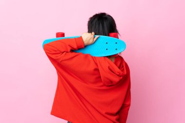 Genç Uruguaylı kadın pembe arka planda, arka planda paten kayıyor.