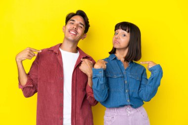 Genç melez çift sarı arka planda soyutlanmış gururlu ve kendini aşktan tatmin etmiş.