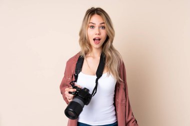 Yüzünde sürpriz ifadeyle izole edilmiş genç fotoğrafçı kız.
