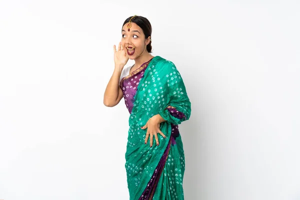 耳に手を置くことによって何かを聞く白い背景に隔離された若いインド人女性 — ストック写真