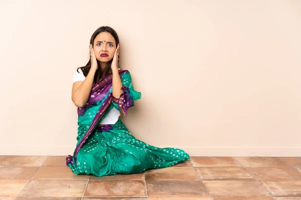 Νεαρή Ινδή Γυναίκα Κάθεται Στο Πάτωμα Απογοητευμένη Και Καλύπτει Αυτιά — Φωτογραφία Αρχείου