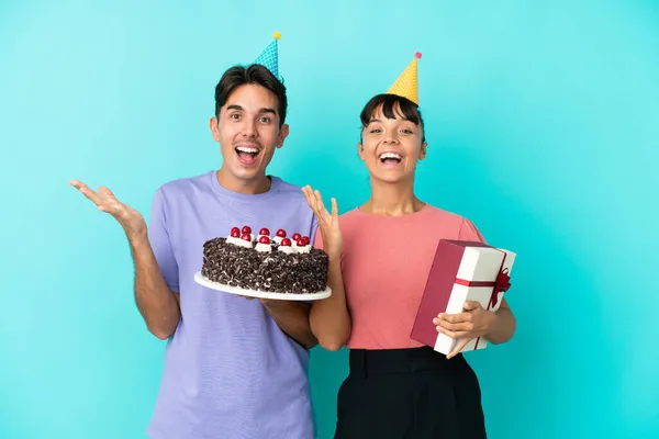 Jovem Casal Misto Segurando Bolo Aniversário Presente Isolado Fundo Azul — Fotografia de Stock